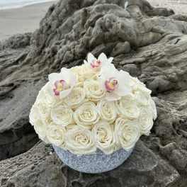 White rose bouquet with white orchids in a round vase