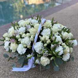 Large white floral basket arrangement with roses and carnations