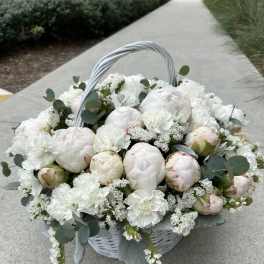 White peony basket arrangement with eucalyptus and a woven handle