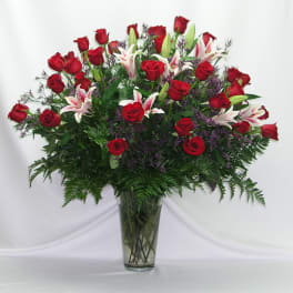 Large bouquet of red roses and white lilies in a clear glass vase