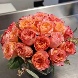 Bouquet of peach and pink roses in a dark vase