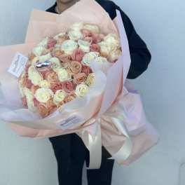 Large bouquet of blush and cream roses wrapped in pale pink paper