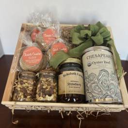 Gift basket with coffee, jam, cookies, and snack jars tied with green ribbon