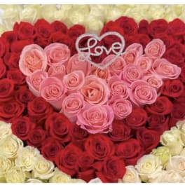 Heart-shaped rose arrangement with a Love topper