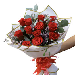 Bouquet of red roses with purple filler in white wrap