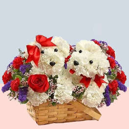 Two white teddy bears in a flower basket with red bows and roses