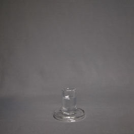 Small clear glass holder with round base on gray background