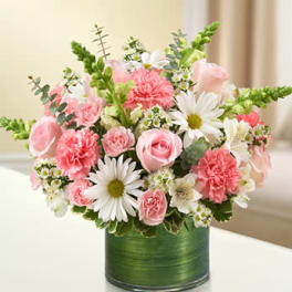 Compact pink and white bouquet with roses, carnations and daisies in a green cylinder vase