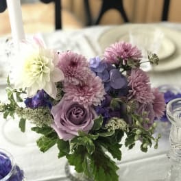 Lavender and pink floral centerpiece in a clear glass vase
