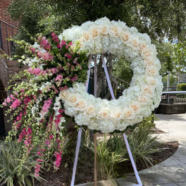Large floral wreath with white roses and hydrangeas, plus pink hanging flowers