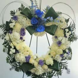 Large floral wreath with blue and white flowers on a stand