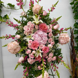 Tall pink floral standing arrangement with roses, hydrangeas, lilies, and snapdragons