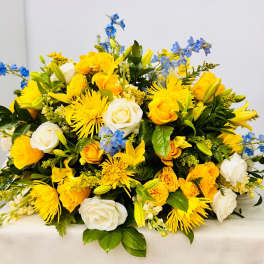 Yellow and white mixed flower arrangement with blue accents