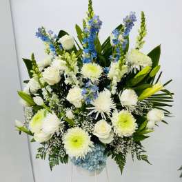 Large white and blue floral standing arrangement on a white stand