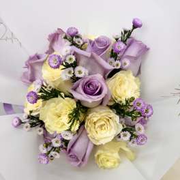 Bouquet of lavender and cream roses with small purple filler flowers