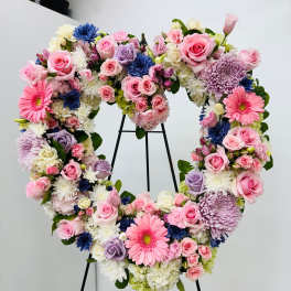 Heart-shaped floral wreath with pink, white, lavender, and blue blooms