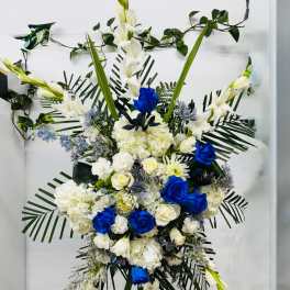 Large standing floral spray with white and blue flowers on an easel