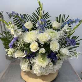 White roses and chrysanthemums with blue flowers in a low arrangement