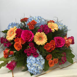 Colorful bouquet with roses, gerbera daisies, and blue hydrangeas