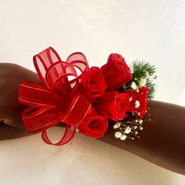 Red rose wrist corsage with ribbon and baby's breath