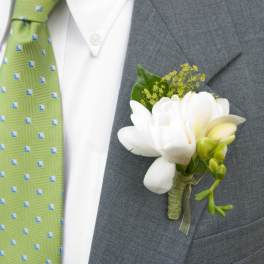 White boutonniere pinned to a gray suit jacket