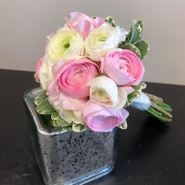 Pink and white ranunculus bouquet in a square glass vase