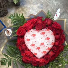 Heart-shaped rose arrangement with a heart decoration in the center