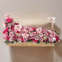 Pink rose and orchid arrangement in a rectangular wooden box