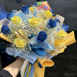 Bouquet of blue and yellow roses with baby's breath and colorful wrapping