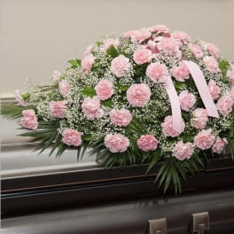 Pink carnation casket spray with baby’s breath and ribbon