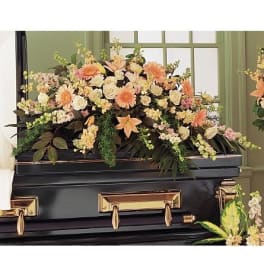 Peach and cream casket spray with roses, lilies, and gerbera daisies on a black casket