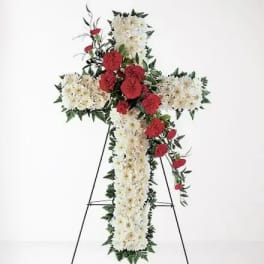 Cross-shaped floral standing spray with white and red flowers on an easel