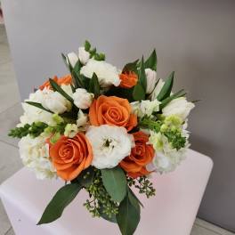 Round arrangement of orange roses and white blooms with green accents in a compact mixed bouquet