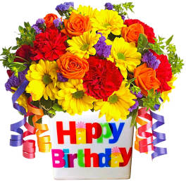 Birthday flower arrangement in a white container with colorful ribbon curls