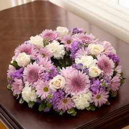 Pastel pink and purple floral wreath with white roses arranged in a ring