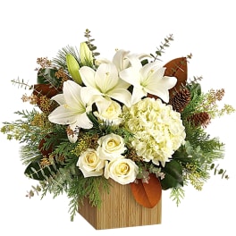 White lilies and roses arranged in a wooden box with greenery