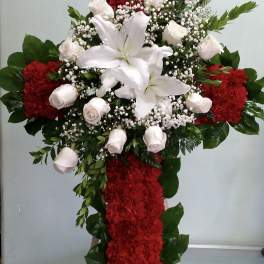 Standing floral cross with white lilies, roses, and red carnations