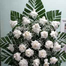 White rose standing spray with large palm leaves and baby's breath