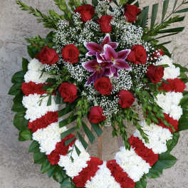 Heart-shaped floral wreath with red roses, white and red carnations, and purple lilies