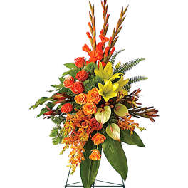 Tall standing floral spray with orange roses and yellow lilies on an easel