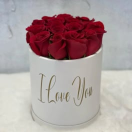Red roses arranged in a white round box with "I Love You" text