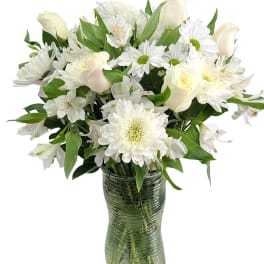 White roses and daisies arranged in a glass vase