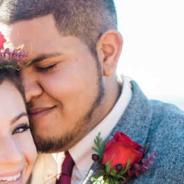 Couple embracing, with a red rose boutonniere on the man's jacket