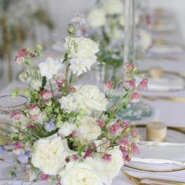 White and pink floral centerpiece on a set table