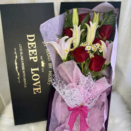 Red roses and white lilies in a gift box with pink wrapping