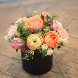Peach and pink mixed bouquet in a black container