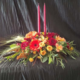 Low floral centerpiece with red candles and mixed autumn flowers