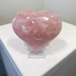 Pink heart-shaped crystal on a clear stand
