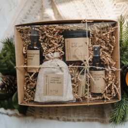 Gift box with bath products and a fabric pouch on shredded paper