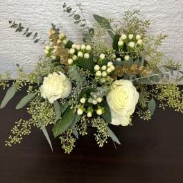 White roses with berries and eucalyptus in a low arrangement
